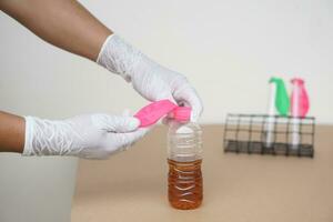 Close up hands hold  flat pink balloon on the top of pop soda bottle to do experiment about chemical reaction. Concept, science experiment about reaction of chemical substance. photo