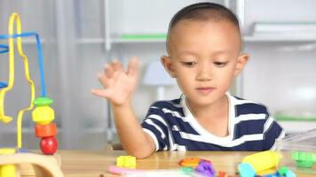 Boy making plasticine to promote development on the table in the house. video
