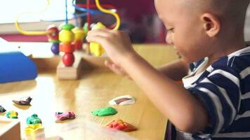 Boy making plasticine to promote development on the table in the house. video