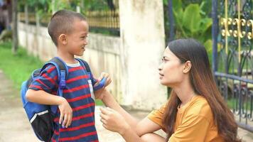 mãe envia dela filho dentro frente do a casa para ir para escola. video