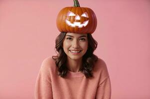 halloween pumpkin hat woman smiling on pink background celebrating with orange and pink colors, AI Generated photo