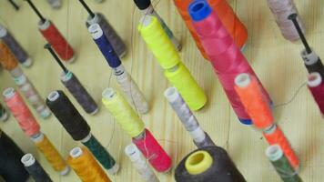 Spools of multi-colored threads in sewing workshop. video