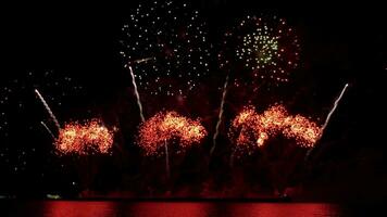 increíble hermosa vistoso Fuegos artificiales monitor terminado mar en celebracion noche. fuegos artificiales espectáculo para contento nuevo año, 4k imágenes. video