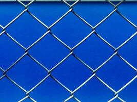 a blue background with a chain link fence photo