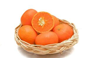 Several orange fruits in a wooden basket Cut the fruit in half to see the seeds inside. natural vitamins photo