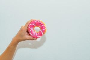 hand woman holding donut pink sweet delicious appetizing photo