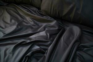 Top view of an unmade black bed with a crumpled sheet, blanket and pillows. AI-Generated photo