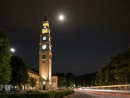 A Clock Tower At Night With A Full Moon In The Sky. AI Generated photo