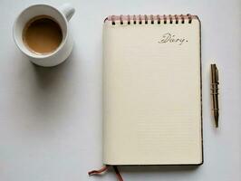 un cuaderno con un bolígrafo y un taza de café. ai generado foto