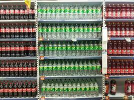 Surakarta, Indonesia. April 27, 2023. Variety of energy drinks, soda, soft drinks, with various brands product in bottles and cans on the shelves in a grocery store supermarket. Beverages industry. photo