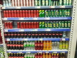 Surakarta, Indonesia. April 27, 2023. Variety of energy drinks, soda, soft drinks, with various brands product in bottles and cans on the shelves in a grocery store supermarket. Beverages industry. photo