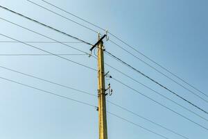 Poste eléctrico de potencia con cable de línea sobre fondo de color cerrar foto