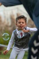 Beautiful baby boy with child soap bubbles posing photographer for cool photo