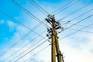 Power electric pole with line wire on colored background close up photo