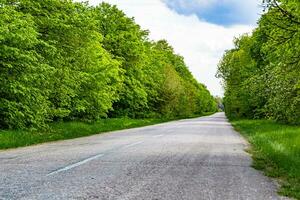 Beautiful empty asphalt road in countryside on colored background photo