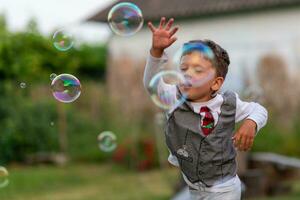 Beautiful baby boy with child soap bubbles posing photographer for cool photo