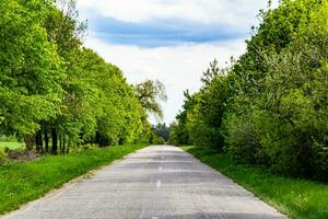 Beautiful empty asphalt road in countryside on colored background photo