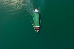 Aerial top view of cargo maritime ship with contrail in the ocean ship carrying container. Neural network AI generated photo