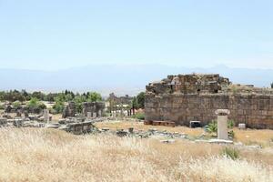 ANTALYA, TURKEY - MAY 15, 2021 Ruins of ancient city Hierapolis near Pamukkale, Turkey at sunny day. Parts of old historical buildings with big blocks photo