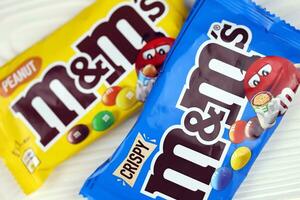 KHARKIV, UKRAINE - JANUARY 2, 2021 M and Ms colorful button shaped chocolate candies. Multi colored chocolates each of which has the letter m printed in lower case in white photo