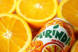 KYIV, UKRAINE - JULY 7, 2023 Mirinda orange drink with many oranges on colorful background photo