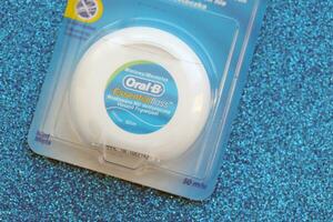 KYIV, UKRAINE - JULY 7, 2023 Oral-B Essentail Floss. Waxed dental floss in round case photo
