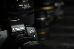 Canon EOS R photocamera with Canon lenses on black table. Canon EOS R is 30mp full-frame mirrorless interchangeable-lens camera launched by Canon in 2018 photo