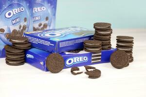 Oreo sandwich cookies and blue product boxes on white table. Oreo is a sandwich cookie with a sweet cream is the best selling cookie in the US photo