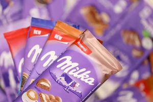 KHARKOV, UKRAINE - DECEMBER 8, 2020 Many wrappings of purple Milka chocolate. Milka is a Swiss brand of chocolate confection manufactured by company Mondelez International photo