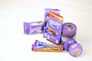 KHARKOV, UKRAINE - JULY 2, 2021 Milka chocolate products with classical lilac color wrapping design on white table photo