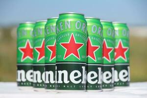 KHARKOV, UKRAINE - JULY 31, 2021 Green tin cans of Heineken lager beer produced by the Dutch brewing company Heineken N.V. photo