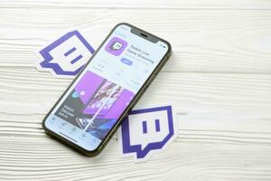 KHARKOV, UKRAINE - MARCH 5, 2021 Twitch icon and application from App store on iPhone 12 pro display screen on white table photo