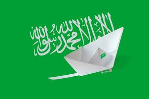 Saudi Arabia flag depicted on paper origami ship closeup. Handmade arts concept photo