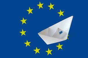 European union flag depicted on paper origami ship closeup. Handmade arts concept photo