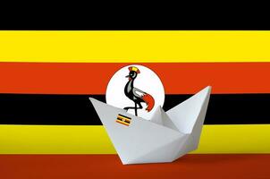 Uganda flag depicted on paper origami ship closeup. Handmade arts concept photo