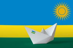 Rwanda flag depicted on paper origami ship closeup. Handmade arts concept photo