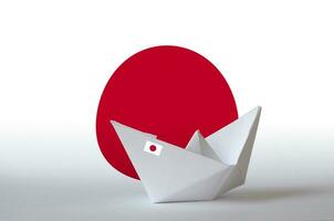 Japan flag depicted on paper origami ship closeup. Handmade arts concept photo