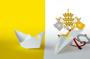 Vatican City State flag depicted on paper origami airplane and boat. Handmade arts concept photo