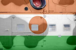 Niger flag depicted on side part of military armored helicopter closeup. Army forces aircraft conceptual background photo