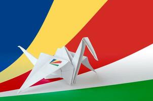 Seychelles flag depicted on paper origami crane wing. Handmade arts concept photo