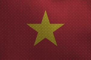 Vietnam flag depicted in paint colors on old brushed metal plate or wall closeup. Textured banner on rough background photo