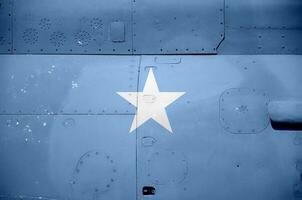 Somalia flag depicted on side part of military armored helicopter closeup. Army forces aircraft conceptual background photo