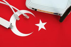 Turkey flag depicted on table with internet rj45 cable, wireless usb wifi adapter and router. Internet connection concept photo