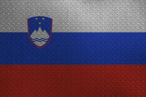 Slovenia flag depicted in paint colors on old brushed metal plate or wall closeup. Textured banner on rough background photo