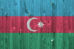 Azerbaijan flag depicted in bright paint colors on old wooden wall. Textured banner on rough background photo