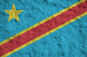 Democratic Republic of the Congo flag depicted in bright paint colors on old relief plastering wall. Textured banner on rough background photo