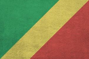 Congo flag depicted in bright paint colors on old relief plastering wall. Textured banner on rough background photo