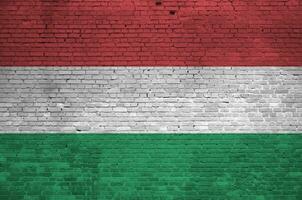 Hungary flag depicted in paint colors on old brick wall. Textured banner on big brick wall masonry background photo