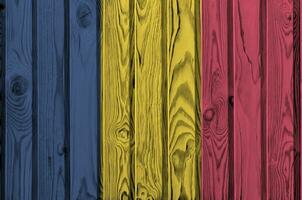 Chad flag depicted in bright paint colors on old wooden wall. Textured banner on rough background photo