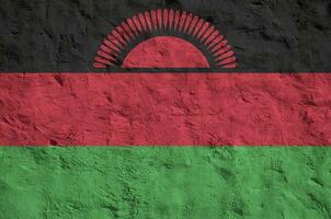 Malawi flag depicted in bright paint colors on old relief plastering wall. Textured banner on rough background photo